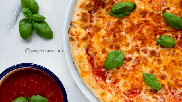 pizza with tomato sauce and basil leaves