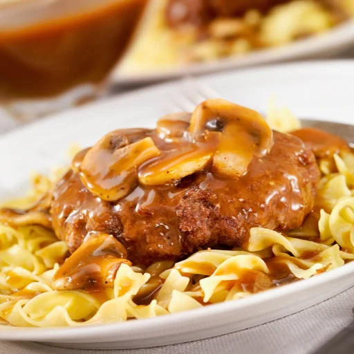 two plates topped with meat and noodles, Salisbury Steak recipe