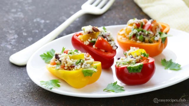 Stuffed Bell Peppers, three stuffed peppers on a white plate with a fork