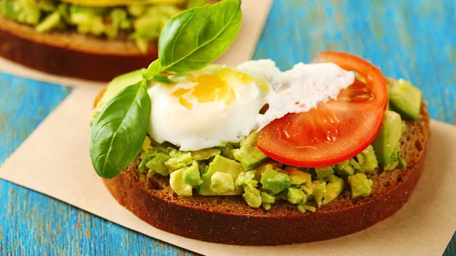 Avocado Toast Recipe two slices of bread topped with avocado, tomatoes and an egg