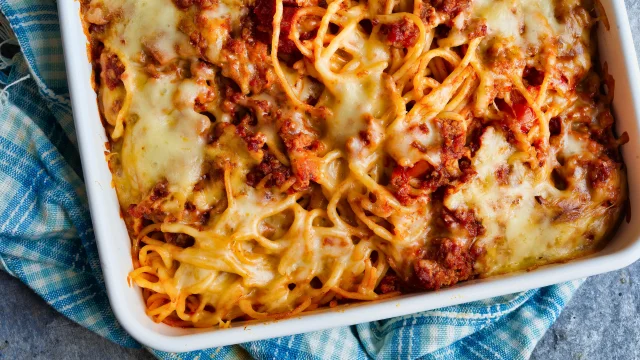 A hearty and delicious Baked Spaghetti recipe, featuring spaghetti noodles layered with a rich meat sauce, creamy cheese mixture, and topped with melted mozzarella. Baked to perfection and garnished with fresh basil leaves for a comforting and satisfying meal.
