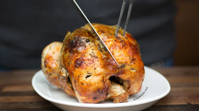 Rotisserie chicken recipes pinning on a rotisserie grill, with juices dripping.