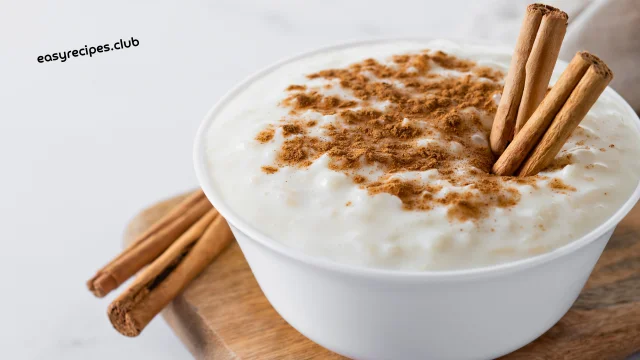 rice pudding recipe with cinnamon and spices in a wooden bowl on a rustic background