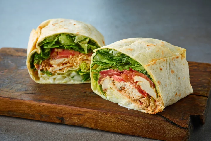 A scrumptious Southwest Chicken Wrap recipe displayed on a wooden plate in a modern kitchen setting, with vibrant colors and a mix of fresh ingredients.
